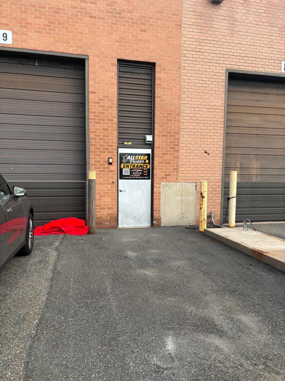 The rear entrance door with the All Star entrance sign, between two loading bays