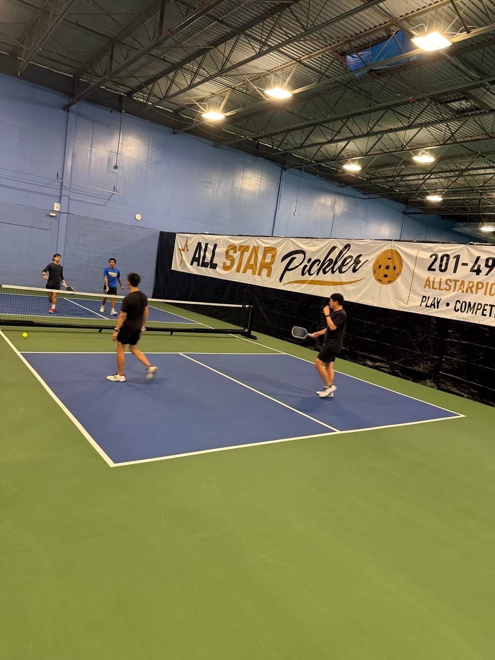 A rally on an All Star court with the club banner behind the players